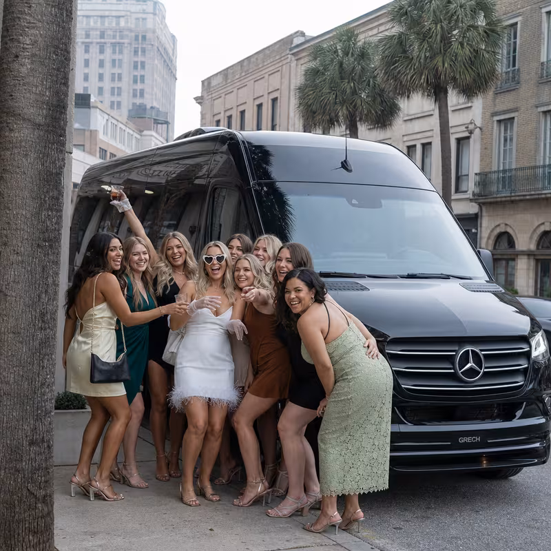 Group boarding a white charter bus for Bachelor & Bachelorette Transportation transportation in Mobile