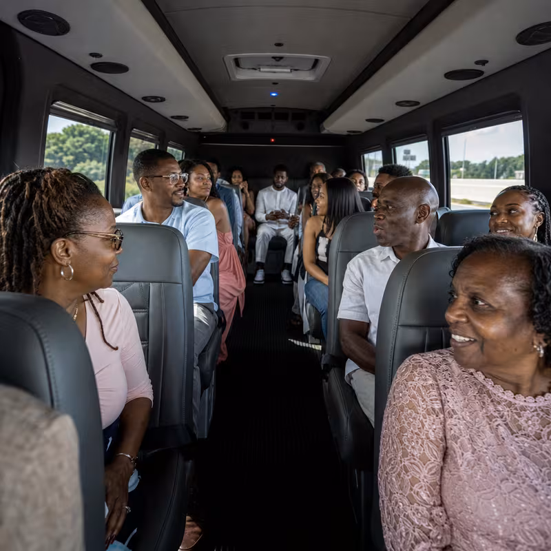 Group boarding a white charter bus for Private Event Transportation transportation in Mobile