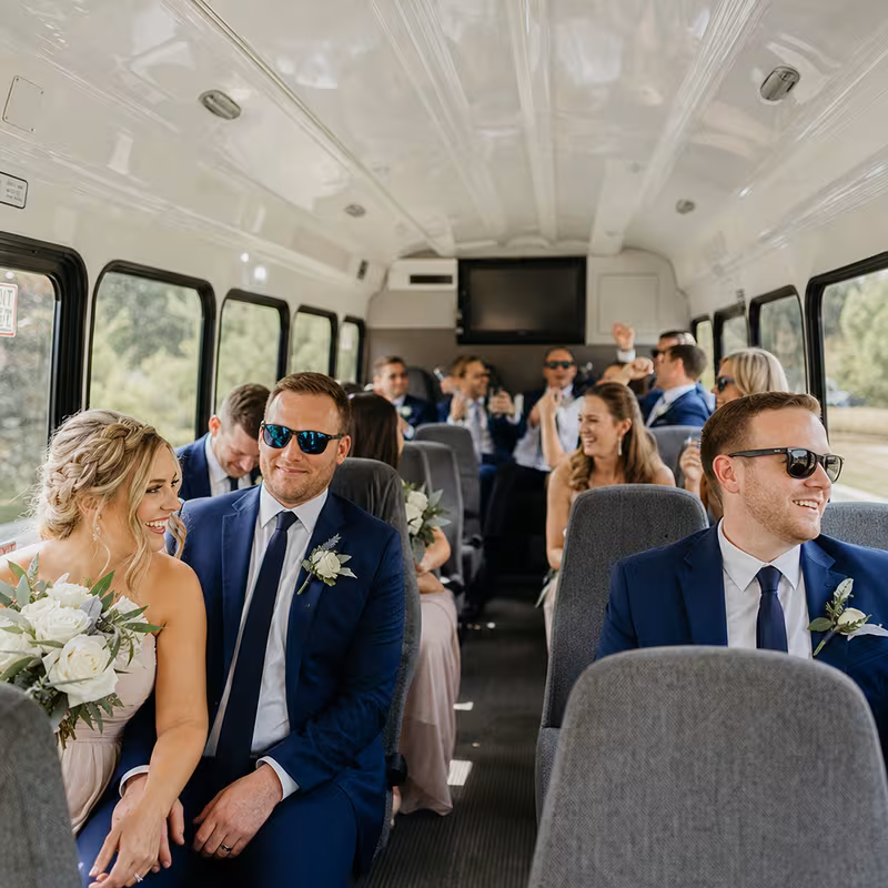 Group boarding a white charter bus for Wedding Transportation transportation in Mobile